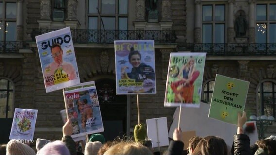 Protestierende Menschen halten Schilder © Screenshot 