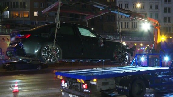 Ein schwarzes Auto der Marke BMW wird mit Totalschaden abgeschleppt © Screenshot 