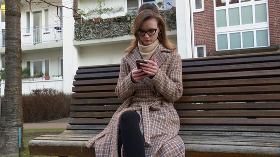 Eine junge Frau sitzt auf einer Bank. © Screenshot 