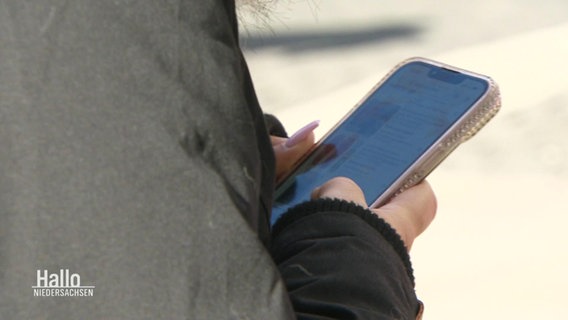 Eine Frau hält ihr Smartphone in den Händen. © Screenshot 