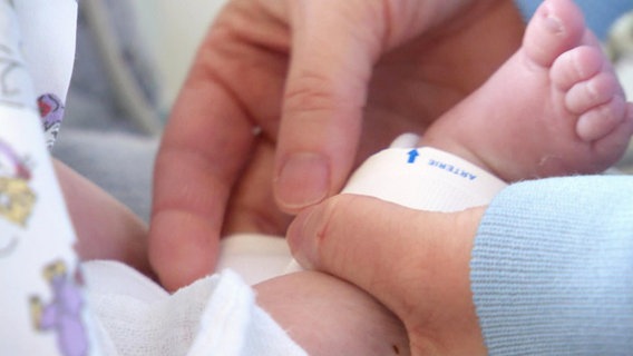 Ein Neugeborenes Baby bekommt sein erstes Armband. © Screenshot 