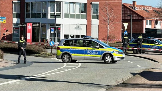 Ein Polizeiauto steht quer auf einer Straße und mehrere Beamte sperren die Straße ab. © Screenshot 