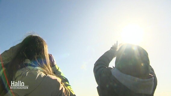 Schülerinnen betrachten ein Flugobjekt am Himmel. © Screenshot 