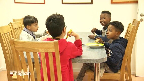 Fünf Kinder an einem Esstisch im Kinderspielzentrum. © Screenshot 