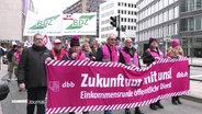 Die Streikenden mit Transparenetn und Fahnen in einem Demonstrationszug © Screenshot 