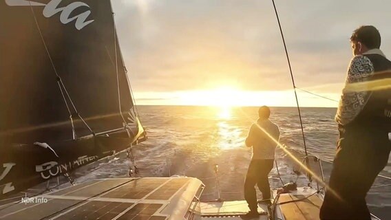 Zwei Männer auf einem Segelschiff fahren auf einen Sonnenuntergang zu © Screenshot 