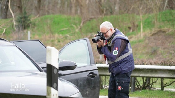 Ein Polizist fotografiert das Innere eines PKW © Screenshot 