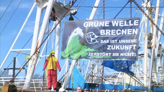 Ein Krabbenkutter mit Protestplakat im Büsumer Hafen.. © Screenshot 