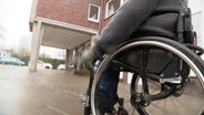 Eine Person im Rollstuh auf dem Bürgersteig © Screenshot 