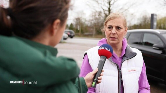 Eine Frau mit einem pinken Kapuzenpullover wird von einer NDR Reporterin interviewt. © Screenshot 