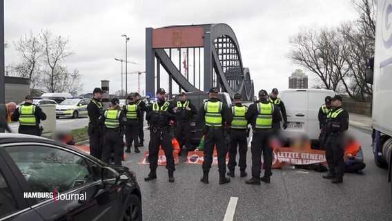 Polizist*innen stehen neben Prostierenden der sog. Letzten Generation. © Screenshot 