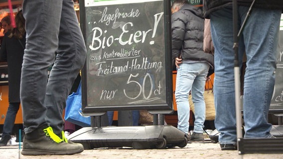 Eine Tafel auf einem Markt wirbt für Bio-Eier. © Screenshot 