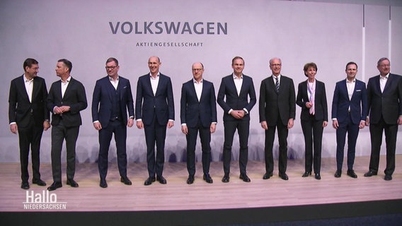 Vorstandsmitglieder von VW stehen auf einer Bühne © Screenshot 