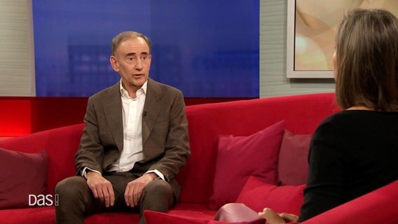 Der Journalist Uwe Jean Heuser sitzt auf dem Roten Sofa bei DAS! © Screenshot 