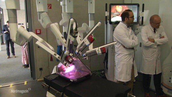 In einem Krankenhaus zeigen Ärzte einen Operationsroboter. © Screenshot 