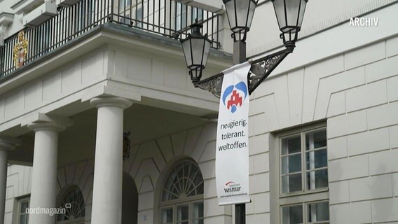 Ein Banner am Rathaus der Stadt Wismar auf dem neugierig. tolerant. weltoffen steht © Screenshot 