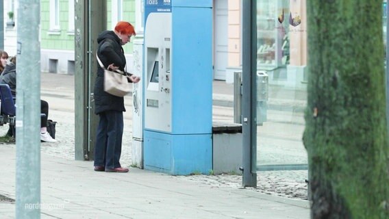 Eine Person steht am Ticketautomaten. © Screenshot 
