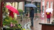 Menschen mit Regenschirm beim Stadtbummel © Screenshot 