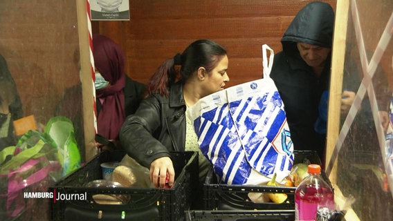 Mehrere Menschen an einer Lebensmittelausgabestelle. © Screenshot 