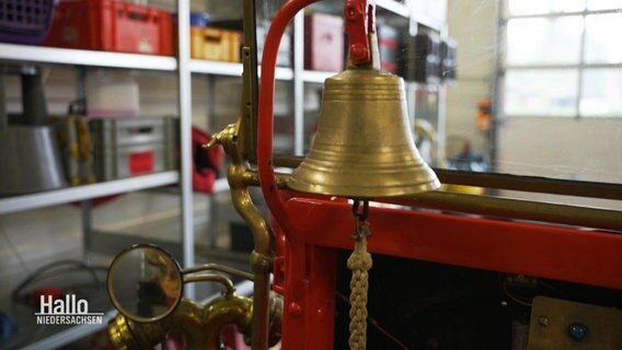 Eine goldene Glocke an einem Oldtimer-Löschfahrzeug. © Screenshot 