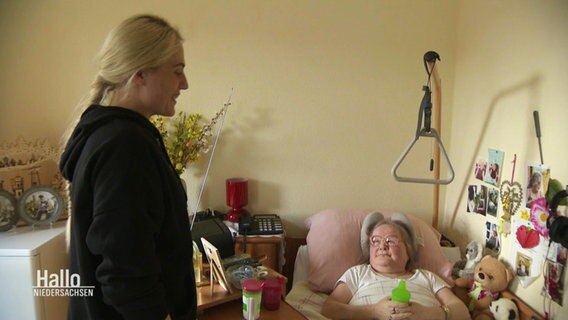 Eine Pflegerin und besucht eine Pflegebedürftige Frau an ihrem Bett. © Screenshot 