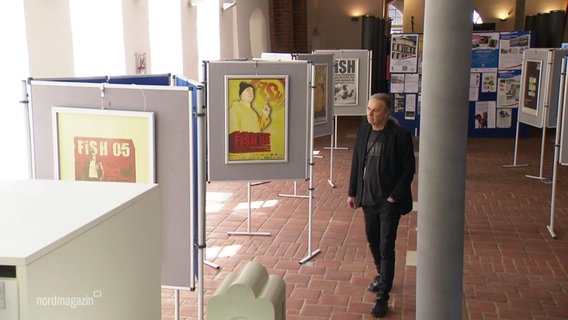 Klaus Blaudzuin, Mitbegründer von FiSH, betrachtet Stellwände mit Postern. © Screenshot 