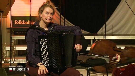 Justine Boesen sitzt mit ihrem Akkordeon auf einer Bühne. © Screenshot 