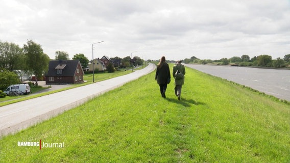 Anja Reimers (li.) und Suscha Vogel-Lobeck gehen über einen Deich spazieren. © Screenshot 