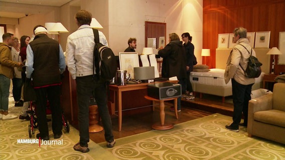 Interessenten stöbern im Hotel "Park Hyatt" durch das zum Verkauf angebotene Inventar. © Screenshot 