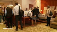 Interessenten stöbern im Hotel "Park Hyatt" durch das zum Verkauf angebotene Inventar. © Screenshot 