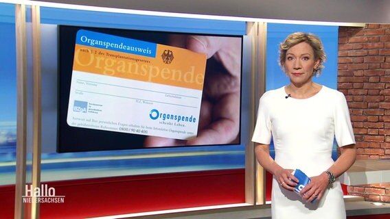Christina von Saß moderiert Hallo Niedersachsen am 04.06.2023. Hinter ihr ist ein Bild eines Organspendeausweises eingeblendet. © Screenshot 