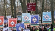 Menschen protestieren mit Schildern gegen ein geplantes LNG-Terminal auf Rügen. © Screenshot 