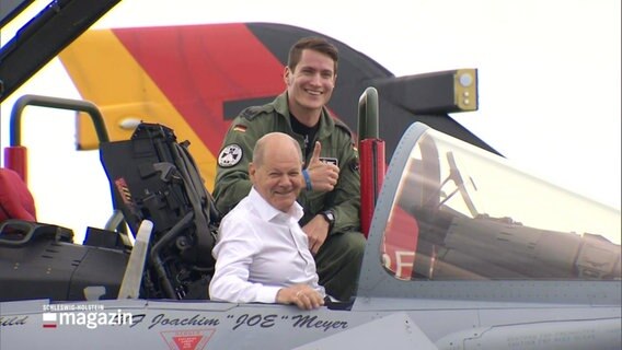 Olaf Scholz sitzt lachend im Cockpit eines Kampfjets. © Screenshot 