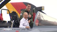 Olaf Scholz sitzt lachend im Cockpit eines Kampfjets. © Screenshot 