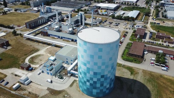 Blick aus der Vogelperspektive auf eine KRaftwerkgelände mit einem zentralen breiten Turm für Energiespeicherung. © Screenshot 