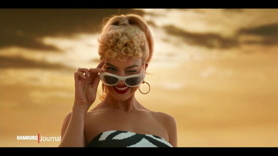 Eine Szene aus dem Film "Barbie": Barbie zwinkert in die Kamera. © Screenshot 