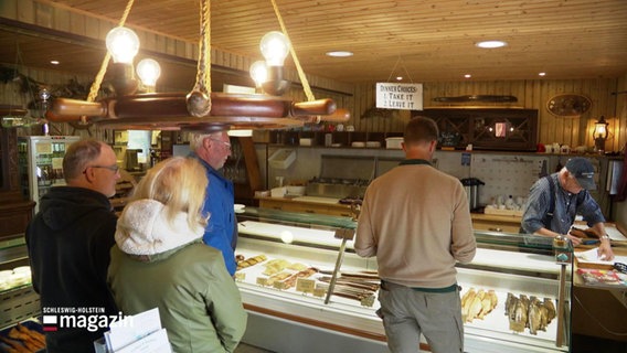 Kundinnen und Kunden an eine Fischtheke. © Screenshot 