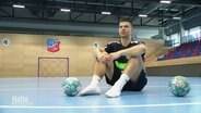 Handballer Renārs Uščins sitzt auf dem Spielfeld © Screenshot 