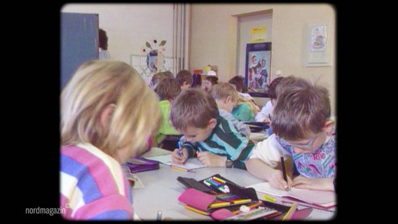 Ein altes Foto von schreibenden Kindern in einem Klassenzimmer. © Screenshot 