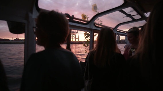 Menschen Tanzen auf einem Boot in der Abenddämmerung. © Screenshot 