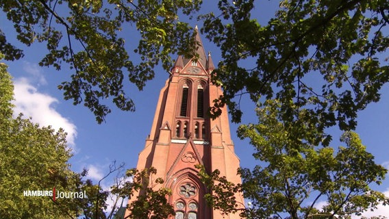 Ein Kirchturm hinter Bäumen. © Screenshot 