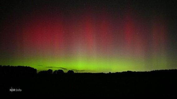 Am Nachthimmel sind grüne und rötliche Lichter zu sehen. © Screenshot 