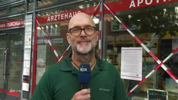 Reporter Torsten Reinke berichtet aus Rostock vor einer Apotheke. © Screenshot 