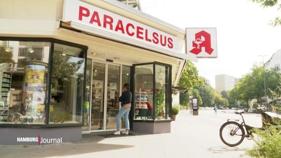 Eine Frau steht vor einer Apotheke in Hamburg. © Screenshot 