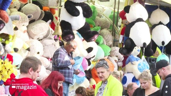 An einem Kirmesstand hängen große Stoff-Pandabären © Screenshot 