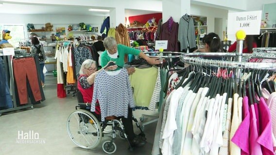 Zwei Frauen schauen sich KLamotten in einem Laden an. © Screenshot 