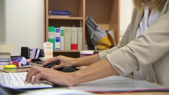 Zwei Hände einer Frau tippen auf einer Computer-Tastatur in einem Büro. © Screenshot 