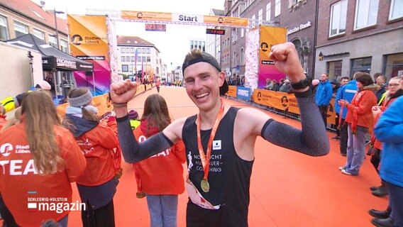 Lars Schwalm jubelt nach seinem Sieg beim Lübeck Marathon in die Kamera. © Screenshot 