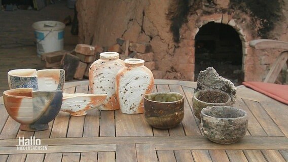 Keramik-Geschirr steht auf einem Holztisch. © Screenshot 