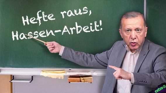 Der türkische Regierungspräsident Recep Tayyip Erdogan mit einem Stock vor einer Tafel auf der "Hefte raus, Hassen-Arbeit!" steht. (extra 3 vom 15.11.2023 im NDR Fernsehen) © NDR 